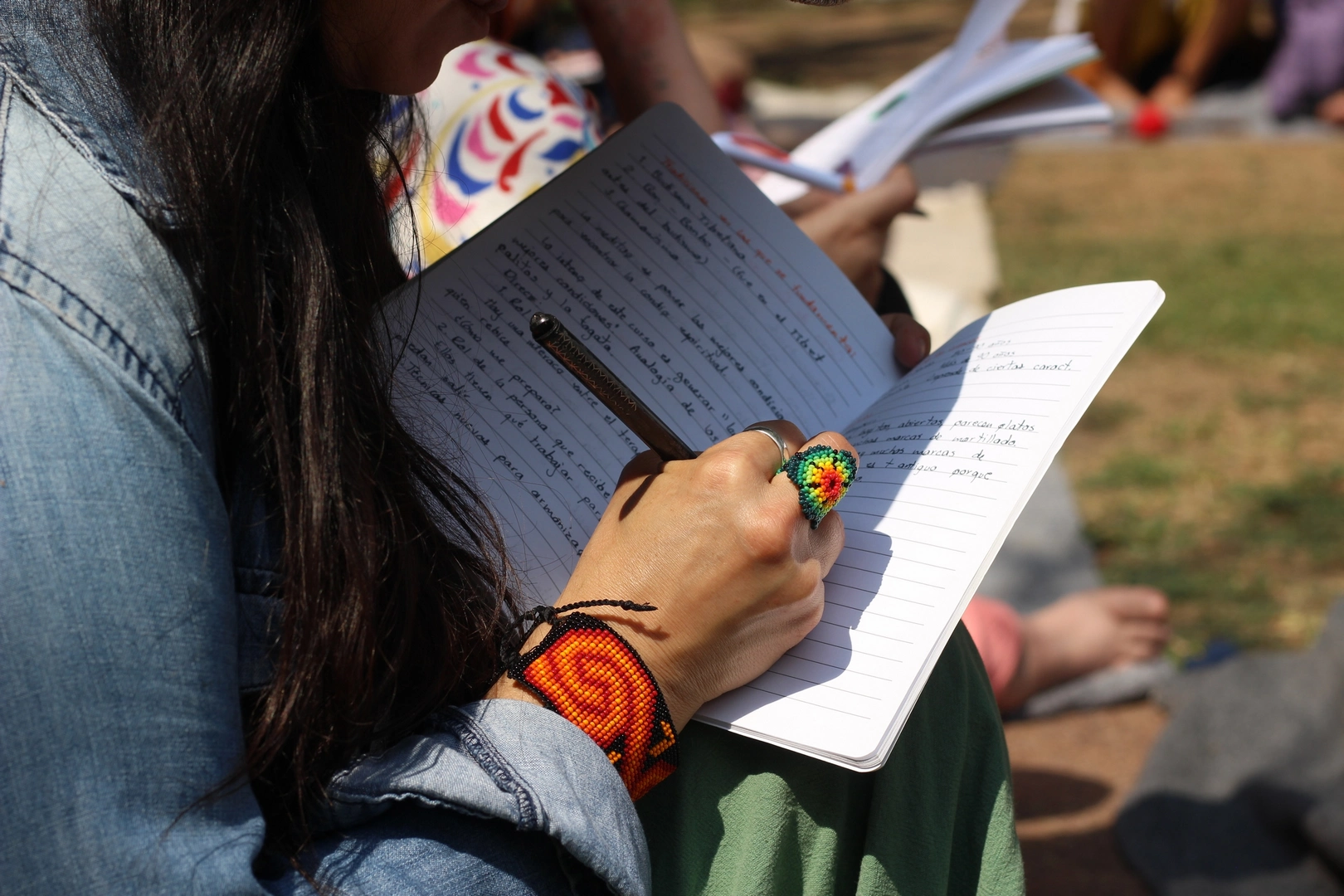 Alumna tomando notas en clase